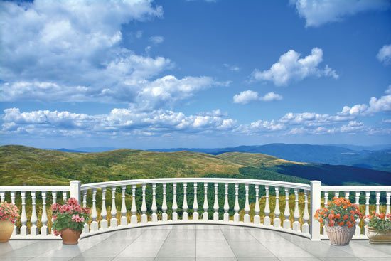 Balcony with views of green hills and blue sky